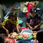 MDG : Child labour : Young girls clean fish at a central fish market Yangoon, Myanmar