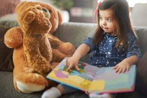 little girl reading book with her teddy bears 329181 9358
