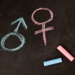 Male and female symbols drawn using chalk on a chalkboard