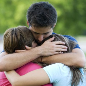 Father hugging children