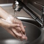 woman washing hands sink close up