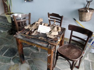 Ο πάγκος του τσαγκάρη είναι γεμάτος με διάφορα εργαλεία και καλαπόδια.