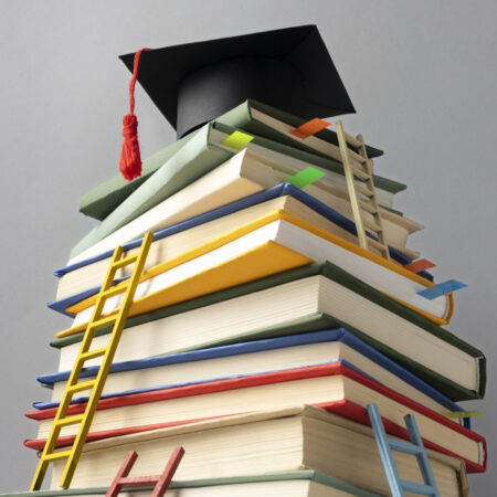 low angle stacked books graduation cap ladders education day